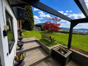 a wooden porch with a bench and flowers on it at Cozy Landscape House, Near pulpit Rock in Strand