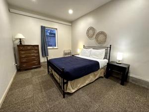 a bedroom with a bed and a dresser and a window at Inn the Clouds Hostel & Inn in Leadville