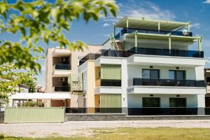 an apartment building with balconies and trees at Karnayo II in Keramoti