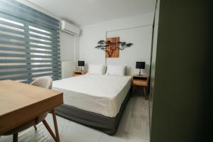a bedroom with a bed and two tables and a desk at Karnayo II in Keramoti