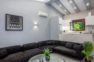 a living room with a couch and a table at NeonChic Jacuzzi and Pool Villa in Sani Beach