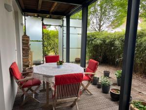 a patio with a table and red chairs at Bei Poldi in Paldau