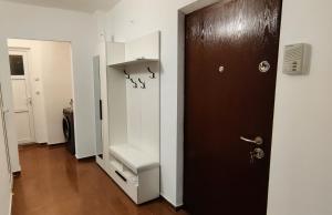 a hallway with a brown door and a white closet at VLC Apartment in Bucharest