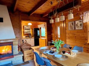 a kitchen and dining room with a fireplace in a log cabin at Sowa i Kumple in Drezdenko +22 photos