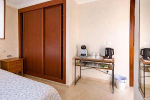 a bedroom with a bed and a table with a phone at Habitación Conde Mar - Terraza y baño privado en Casa Particular in Ayamonte