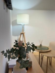 a plant in a vase on a table with a lamp at Modern Design Apartment Salona I Stylish & Comfortable Solin I Split in Solin