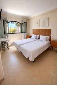 a bedroom with two beds and a window at Habitación Conde Mar - Terraza y baño privado en Casa Particular in Ayamonte