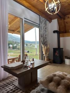 a living room with a table and a large window at Etno Villa Popovic in Žabljak