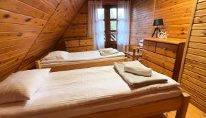 a bedroom with two beds in a wooden cabin at Sowa i Kumple in Drezdenko