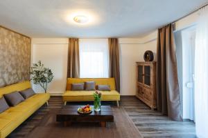 a living room with a yellow couch and a table at Boutique Apartments Daniela in Faak am See