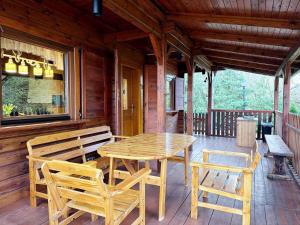 a wooden table and chairs on the porch of a cabin at Sowa i Kumple in Drezdenko