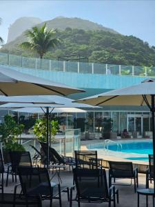 a group of chairs and umbrellas next to a swimming pool at Hotel Nacional in Rio de Janeiro