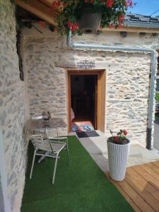 a patio with a chair and a table and a building at Le coquelicot -Draps inclus in Val Cenis +1 photo