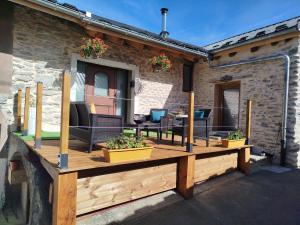 a wooden deck with chairs and a table on a building at Le coquelicot -Draps inclus in Val Cenis