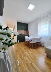 a living room with a table and chairs and a kitchen at Apartmani Marija - Vila Marija in Šilo