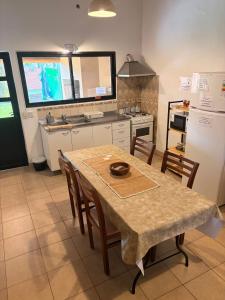 a kitchen with a table with chairs and a refrigerator at La Casita El Martillo in Concordia +12 photos