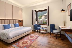 a bedroom with a bed and a desk and a window at Kanishka, Manali - AM Hotel Kollection in Manāli