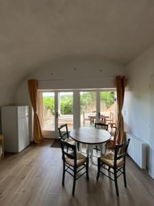 a dining room with a table and chairs and a window at voute atypique 40 m2 in Montaigut-le-Blanc +20 photos