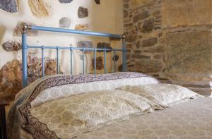 a bed with a blue head board in a room at Next to the Bougainvillea! in Ano Syros +12 photos