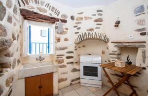 a kitchen with a sink and a stove at Next to the Bougainvillea! in Ano Syros