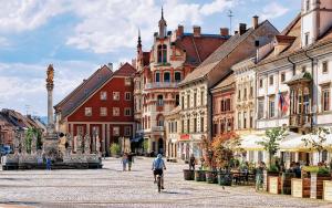a man riding a bike down a city street at DINLUX Luxury Apartment in Maribor