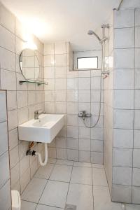 ein weißes Badezimmer mit Waschbecken und Dusche in der Unterkunft Elgrecosuits in Limenaria