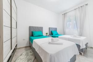 two beds in a room with blue and white at Prcanj Seaside Heaven in Prčanj
