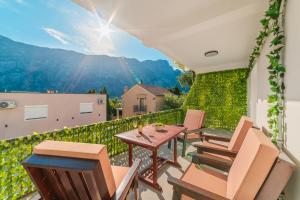 a patio with chairs and a table on a balcony at Prcanj Seaside Heaven in Prčanj