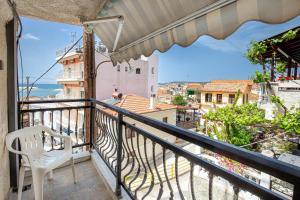ein Balkon mit einem weißen Stuhl und Meerblick in der Unterkunft Elgrecosuits in Limenaria