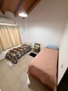 a bedroom with two beds and a chair at La Casita El Martillo in Concordia