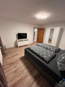 a bedroom with a bed and a flat screen tv at Ferienwohnung Marcello in Adenau