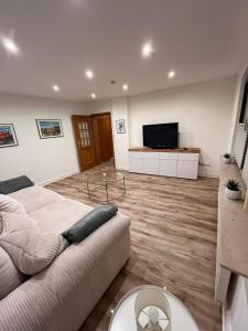 a living room with a couch and a flat screen tv at Ferienwohnung Marcello in Adenau