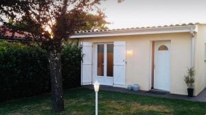a small white house with a tree in the yard at Studio Cosy in Saint-Juéry