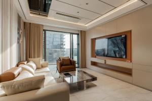 a living room with a couch and a tv at ChiHome Metropole The Opera Residence Luxury in Ho Chi Minh City