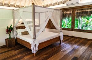 a bedroom with a bed with mosquito net at Casa Bambu Tayrona, Los Naranjos in Los Naranjos
