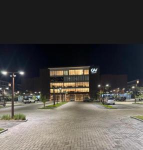 a large building with cars parked in a parking lot at Gav 2 Life in Ipojuca
