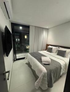 a bedroom with a large bed with two towels on it at Gav 2 Life in Ipojuca
