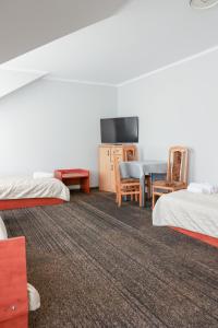 a hotel room with two beds and a television at Noclegi Królów in Królów