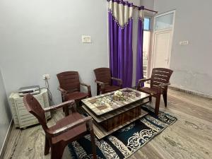 a dining room with a table and chairs and purple curtains at 2BHK Ground Floor Private House- Raj Shila in Kānpur