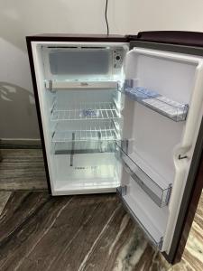an empty refrigerator with its door open in a room at 2BHK Ground Floor Private House- Raj Shila in Kānpur