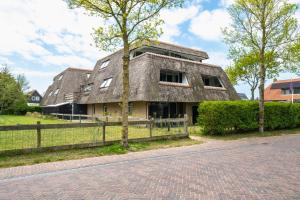 an old house with a thatched roof on a street at Waddenresidentie Ameland - 2 en 4 persoons appartementen in Buren