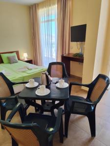 a room with a table and chairs and a bed at Амон Ра 2 in Primorsko
