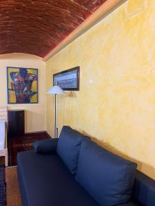 a living room with a blue couch against a yellow wall at Bei Poldi in Paldau