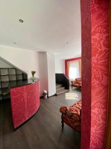 a living room with a couch and a red wall at Casa Nelda in Marginea