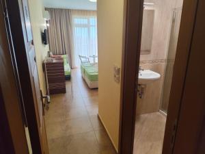 a room with a bathroom with a bed and a sink at Амон Ра 2 in Primorsko +29 photos