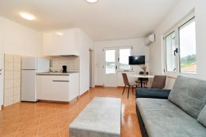 a living room with a couch and a kitchen at Dzon Beachside Apartments in Vinišće