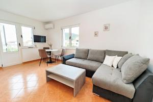 a living room with a couch and a table at Dzon Beachside Apartments in Vinišće