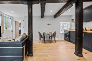 a kitchen and dining room with a table and chairs at Modern & Historic Mill Flat with Stream Views in Godalming