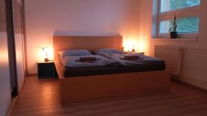 a bed in a room with two lamps and a window at Apartmán Istebné luxure in Istebné