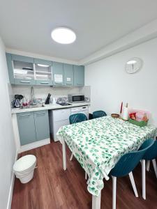 a kitchen with a table and blue cabinets at Paris maison-4min à Métro7-18min au centre de Paris in Villejuif